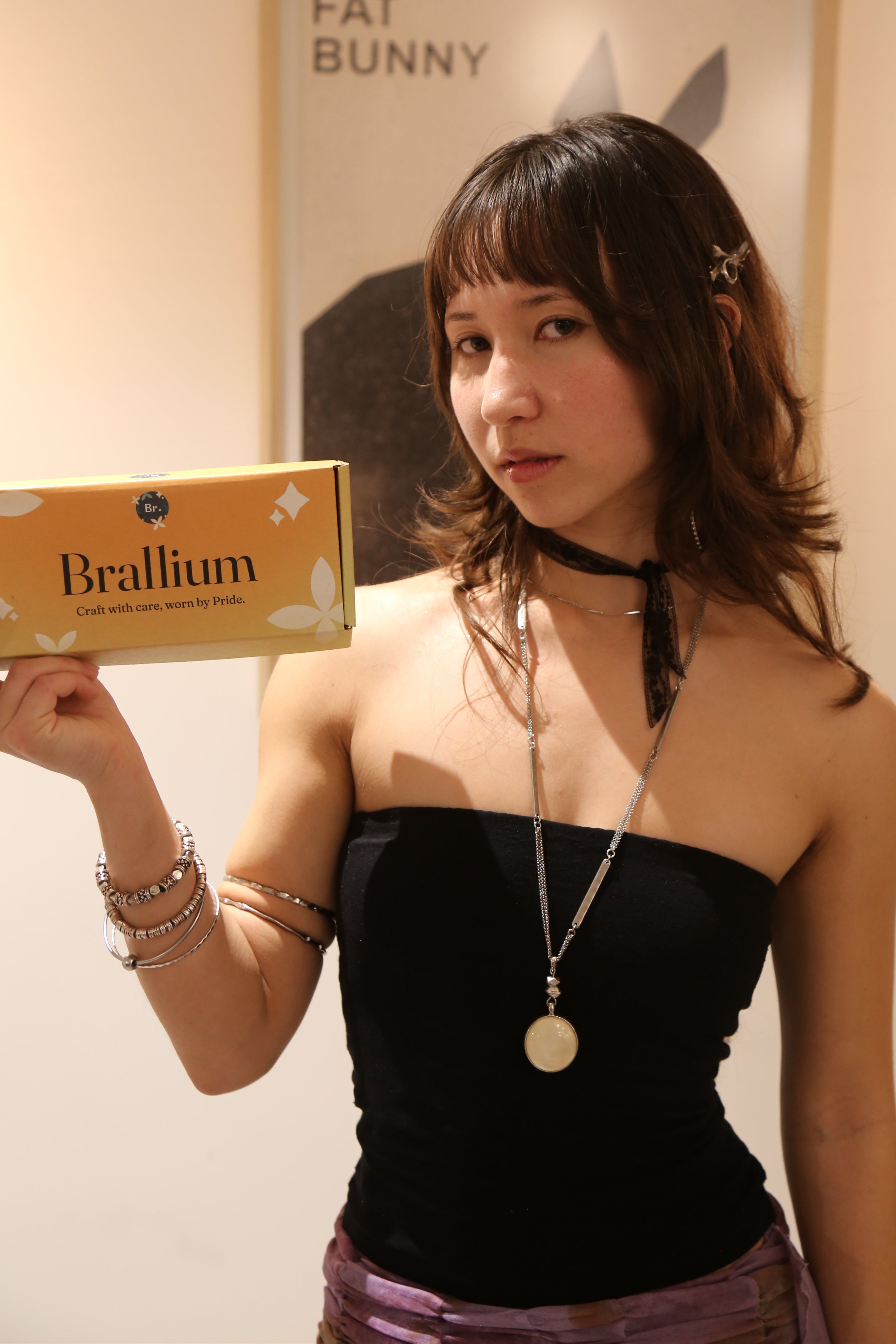 Woman holding a box labeled Brallium